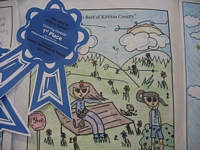 The Best of Kittitas County Coloring Contest Entry - Drawing of a girl on a bench with a cat and a girl listening to headphones on a windy day with grassy, flowery hills