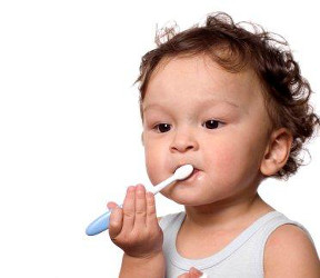 Infant brushing teeth with toothbrush